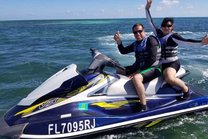 a group of people riding on the back of a boat in the water