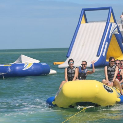 a group of people riding on the back of a boat in the water