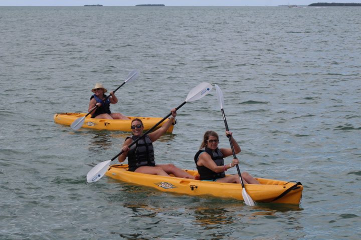 a group of people riding on the back of a boat in the water