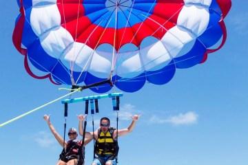 a person flying through the air on a parachute