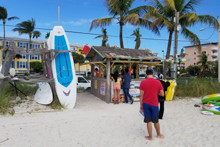 a group of people on a beach holding a surf board