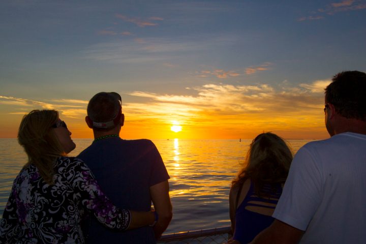 a group of people standing next to a body of water